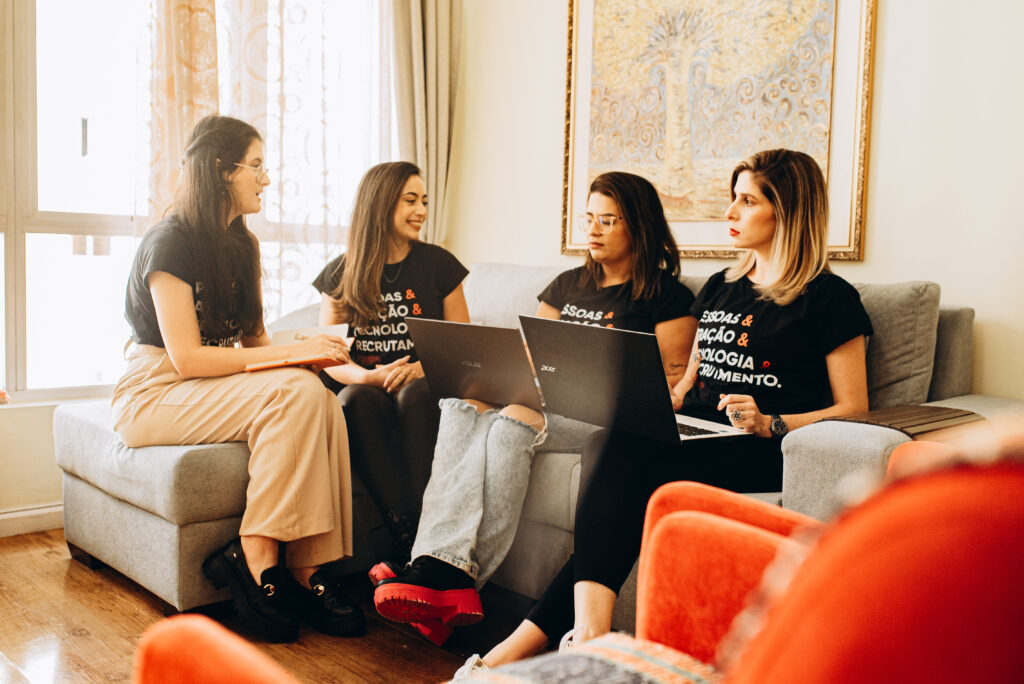 Quatro mulheres da Singularis RH conversando em um sofá sobre consultoria de RH