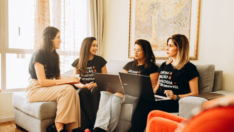 Quatro mulheres da Singularis RH conversando em um sofá sobre consultoria de RH